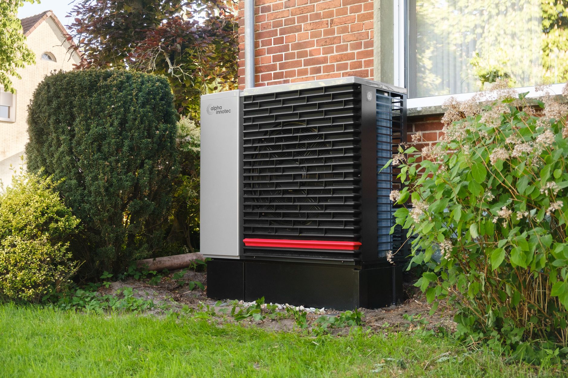 Buitenunit van een warmtepomp tegen een gevel